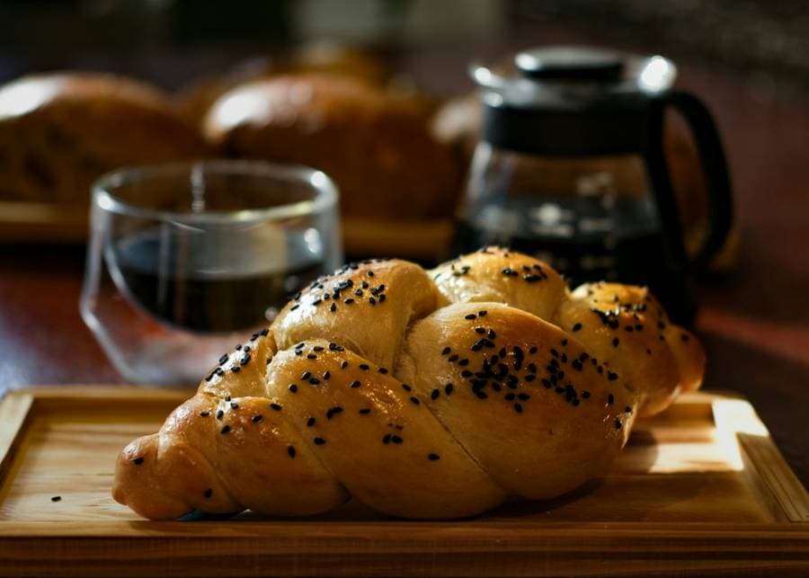 Challah trenzada recién horneada sobre una tabla de madera